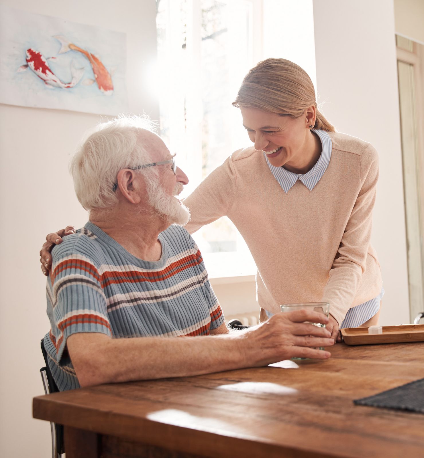 Eine Pflegekraft kümmert sich zu Hause um einen Senior